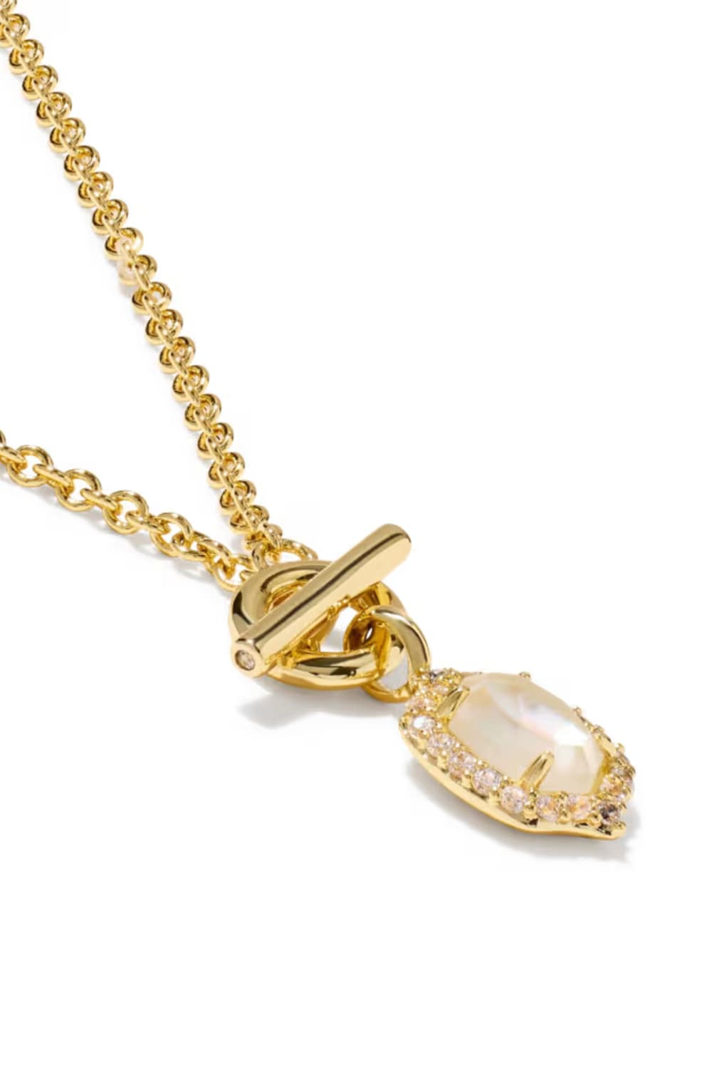 A gold chain necklace with a toggle clasp and a teardrop-shaped pendant featuring a milky white stone surrounded by small clear stones, shown on a white background.