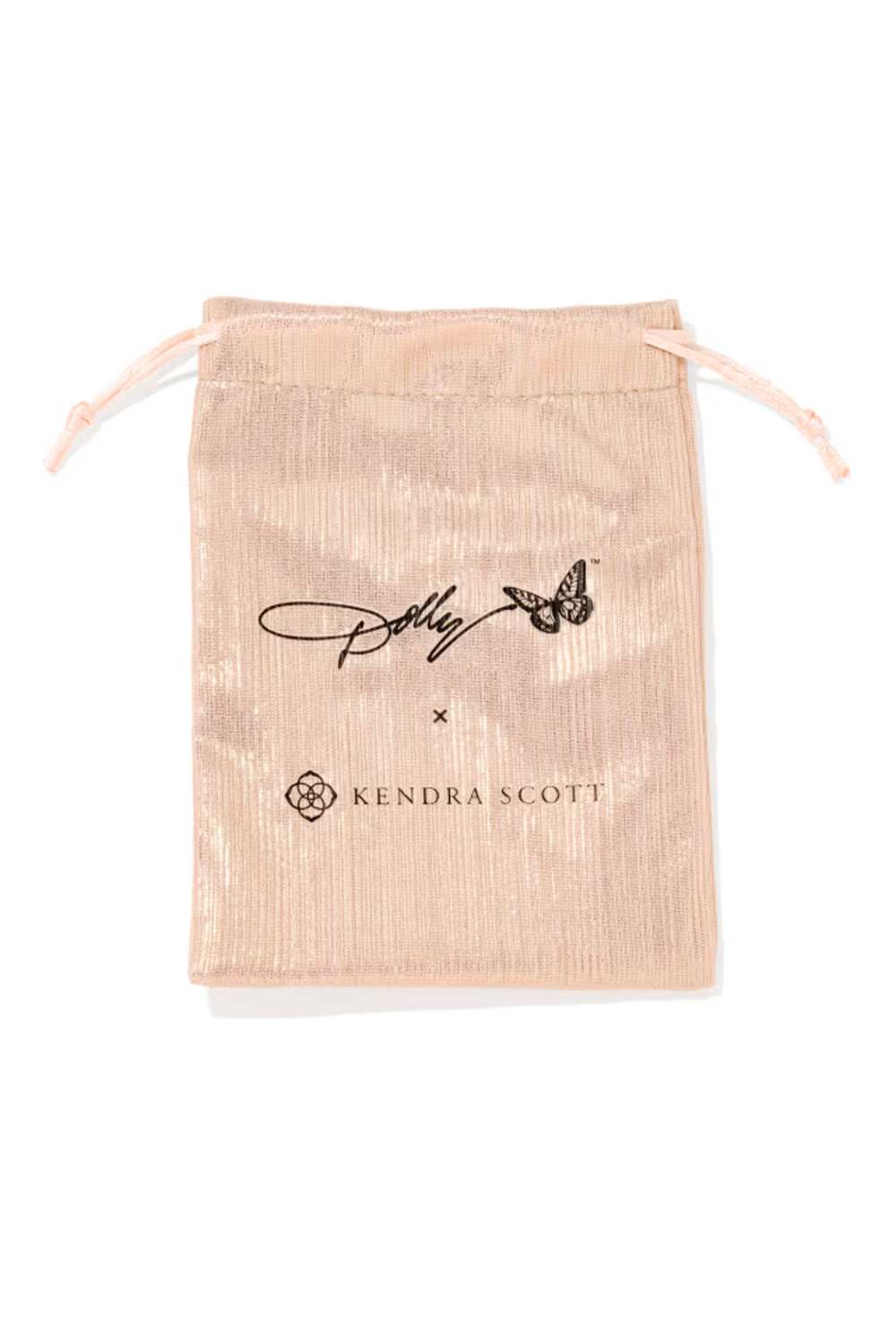 A metallic blush pink drawstring pouch with black printed branding for a Kendra Scott x Paddywax collaboration, shown on a clean white background.