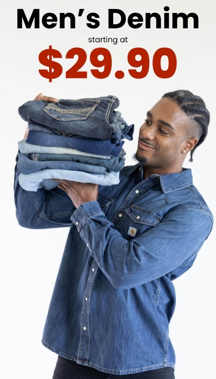 A promotional image of a man wearing a long sleeve button up denim shirt holding a stack of denim jeans with a dark overlay on top of the image. Text at the top of image reads Men's Denim starting at $29.90