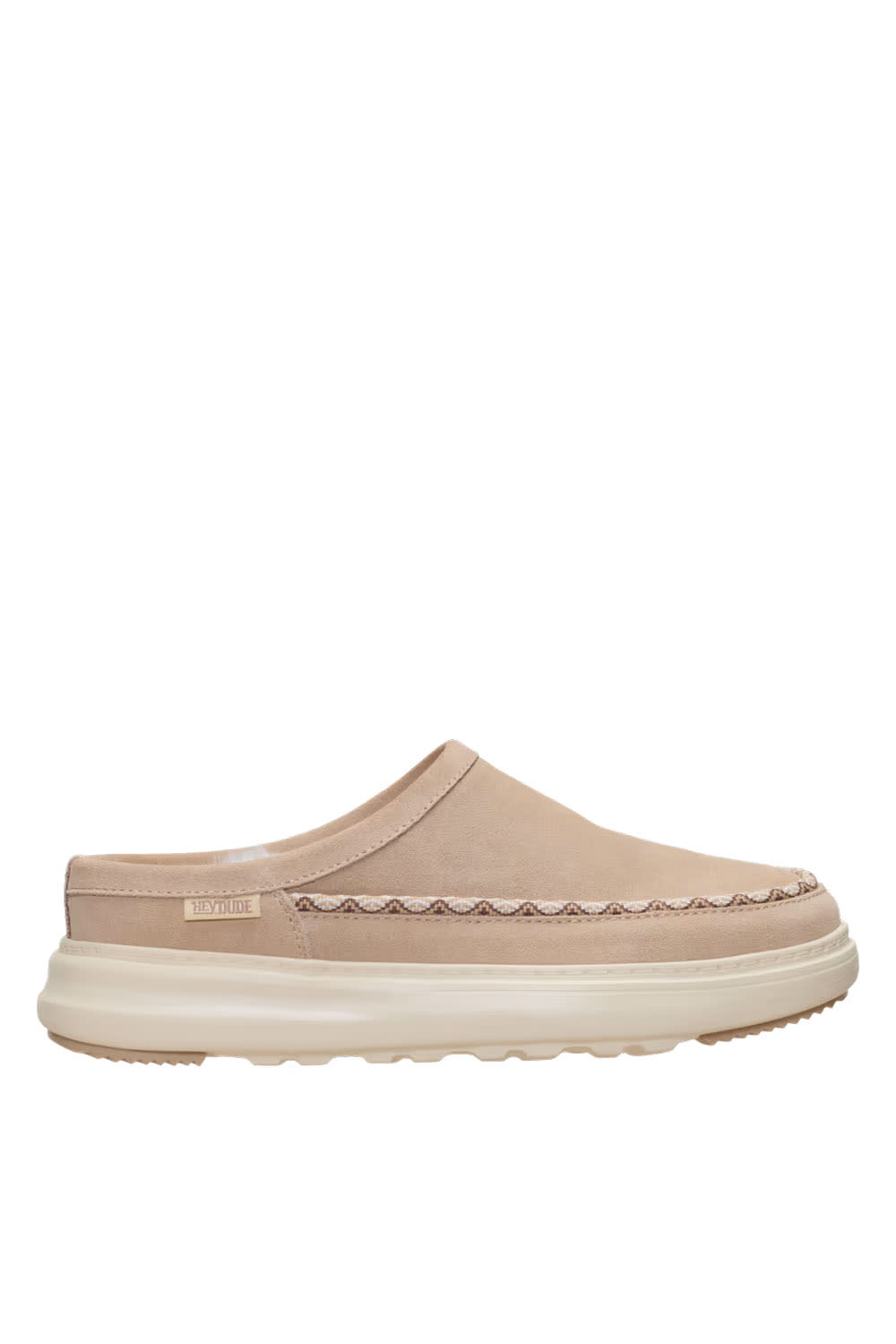 A single slip-on clog-style shoe in a light beige suede-like material with a thick cream sole and a decorative stitched detail across the vamp, shown against a plain white background.