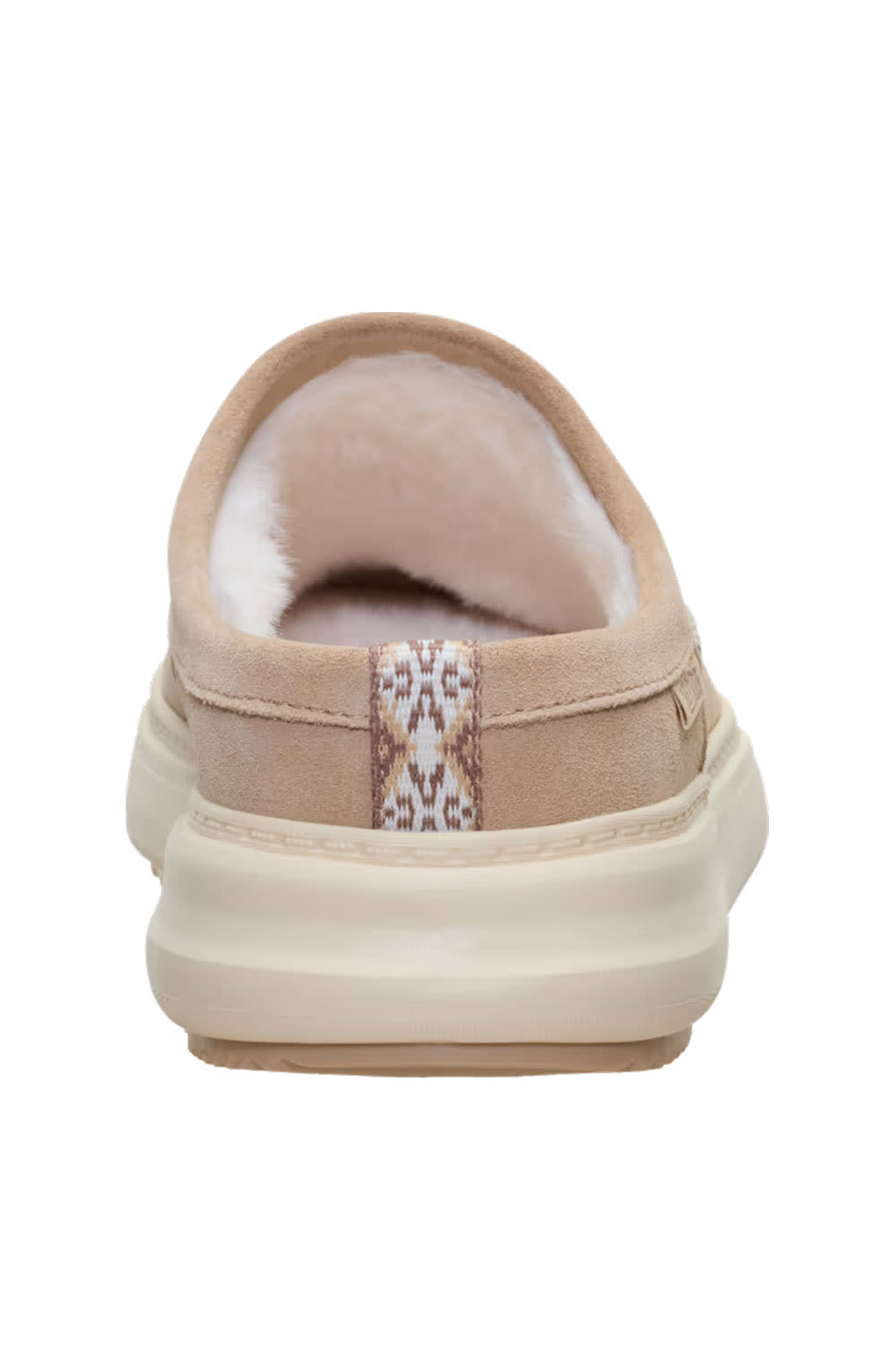 A single slip-on clog-style shoe shown from the back, featuring a beige suede upper, a plush cream shearling lining, and a patterned heel tab on a white background.