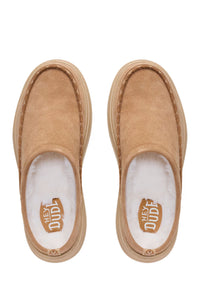 A pair of tan suede slip-on slippers with white plush lining and a tan rubber sole, shown from a top-down view on a white background. The brand logo HEY DUDE is visible on the insole.