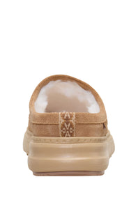A single tan slip-on clog-style shoe with a plush white shearling lining and a thick tan sole, shown from the back against a white background.