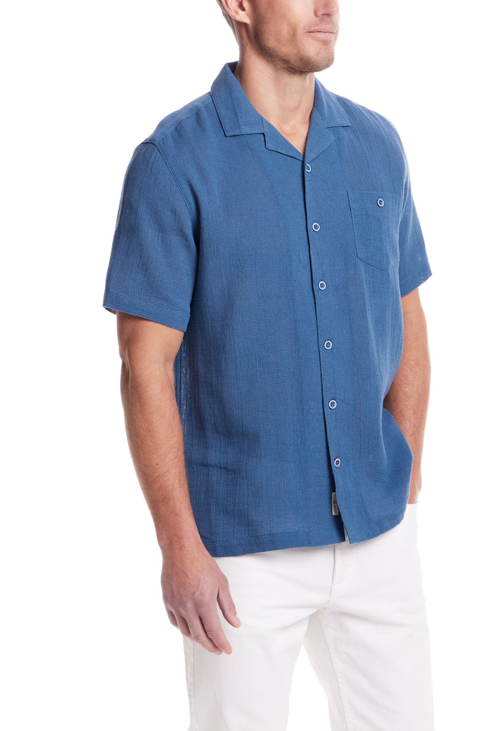 Weatherproof Vintage Cotton Airtex Shirt for Men in Blue Ashes; Man wearing a blue short-sleeve button-up shirt with white pants on a white background