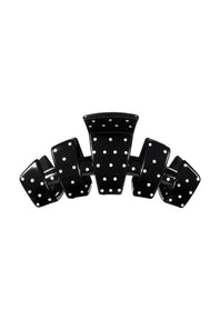 A glossy black claw hair clip with white polka dots, displayed against a solid white background.