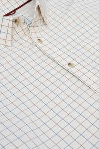 Close-up of a white button-up shirt with a fine blue and red windowpane check pattern, showing the collar, button placket, and fabric texture.