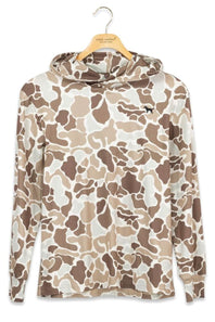 A hooded long-sleeve shirt with an all-over camouflage pattern in beige, brown, and off-white, hanging on a wooden hanger against a plain white background. A small black animal logo is visible on the left chest.