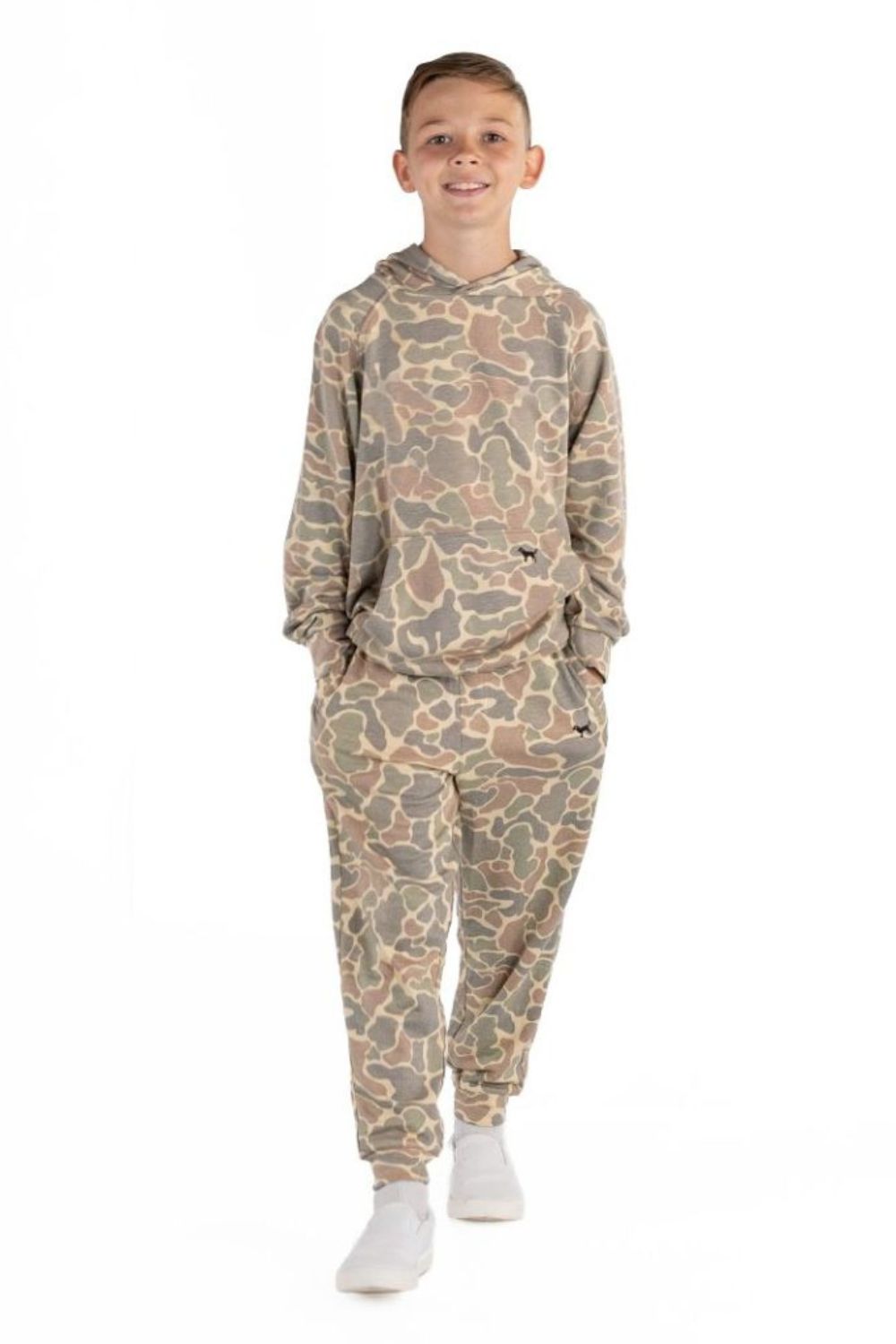 A young boy modeling a matching camouflage hoodie and jogger pants set, standing against a plain white background.