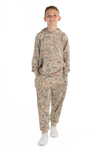 A young boy modeling a matching camouflage hoodie and jogger pants set, standing against a plain white background.