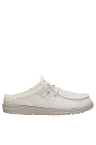A white quilted slip-on mule shoe with a soft white faux-fur lining and a beige sole, shown in a side profile view against a plain white background.