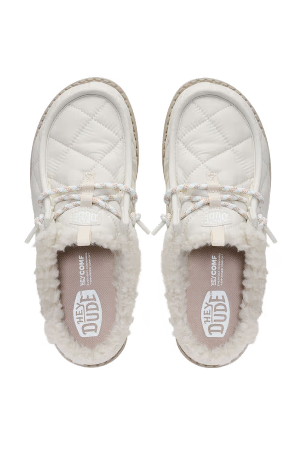 A pair of HEYDUDE slip-on shoes in off-white, featuring quilted leather uppers, white faux-fur lining, braided laces, and a visible HEYDUDE logo on the insole, shown from a top-down view on a white background.