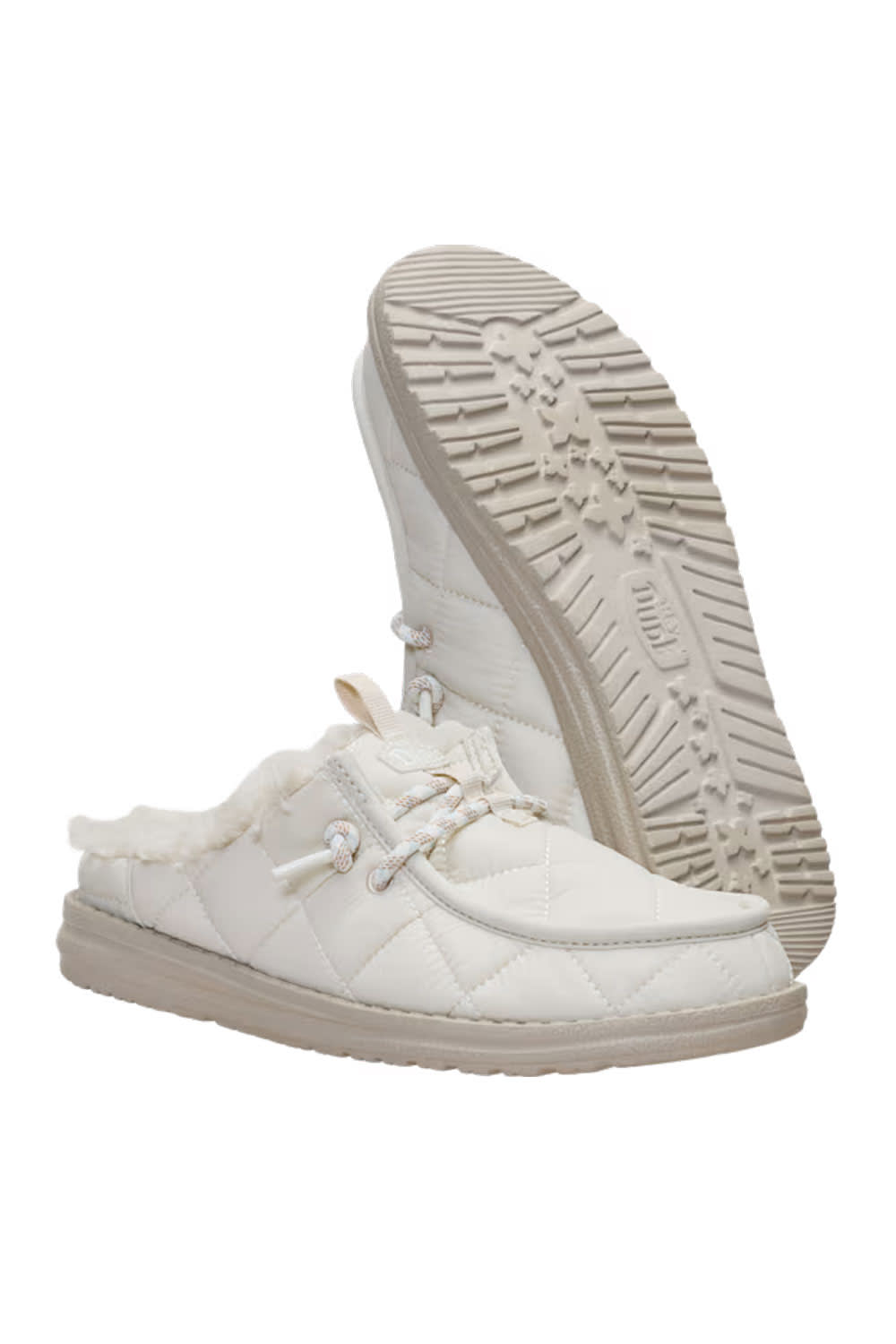 A pair of off-white quilted slip-on moccasin-style shoes with faux fur lining, shown with one shoe standing upright to display the sole tread and the other lying flat to show the side profile.